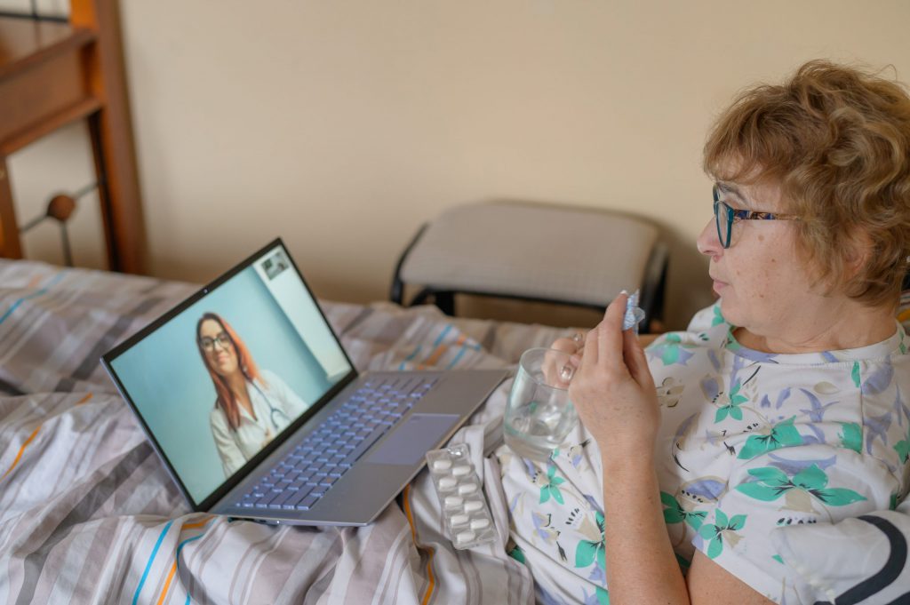 An elderly woman is talking with a doctor.