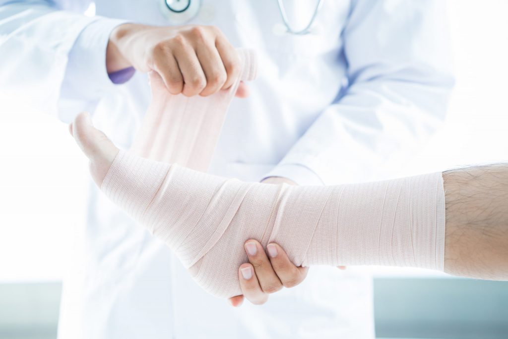 Nurse wrapping wounded foot