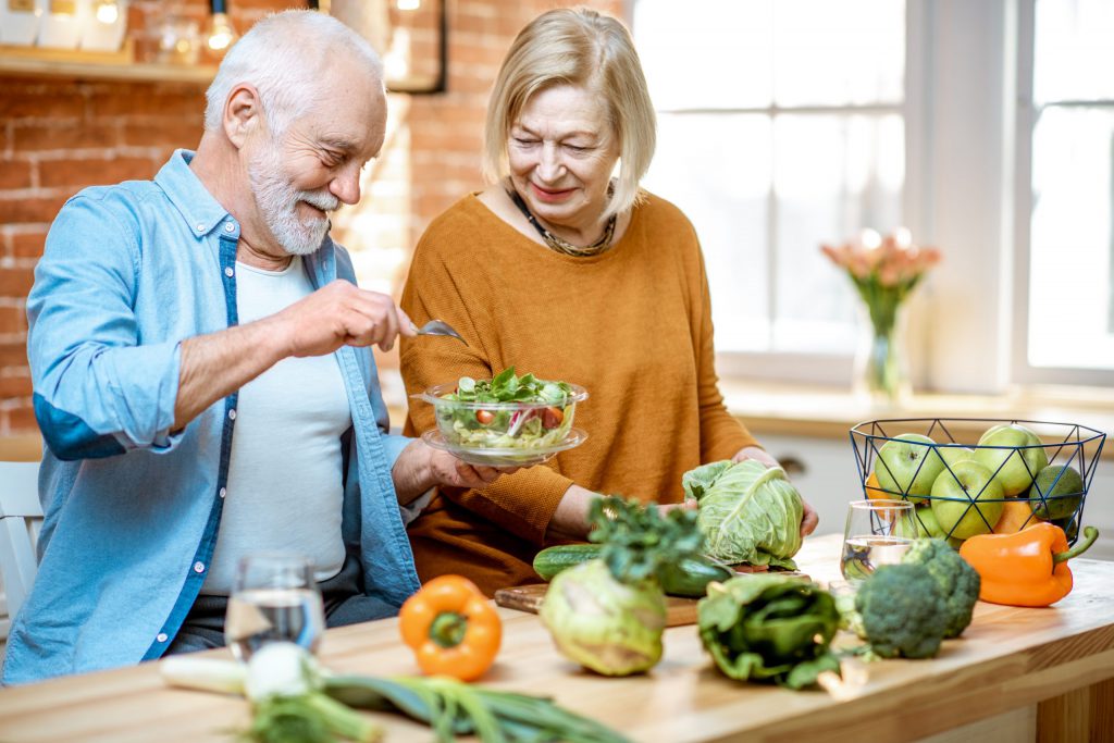 Couple having fun and preparing salad dish together