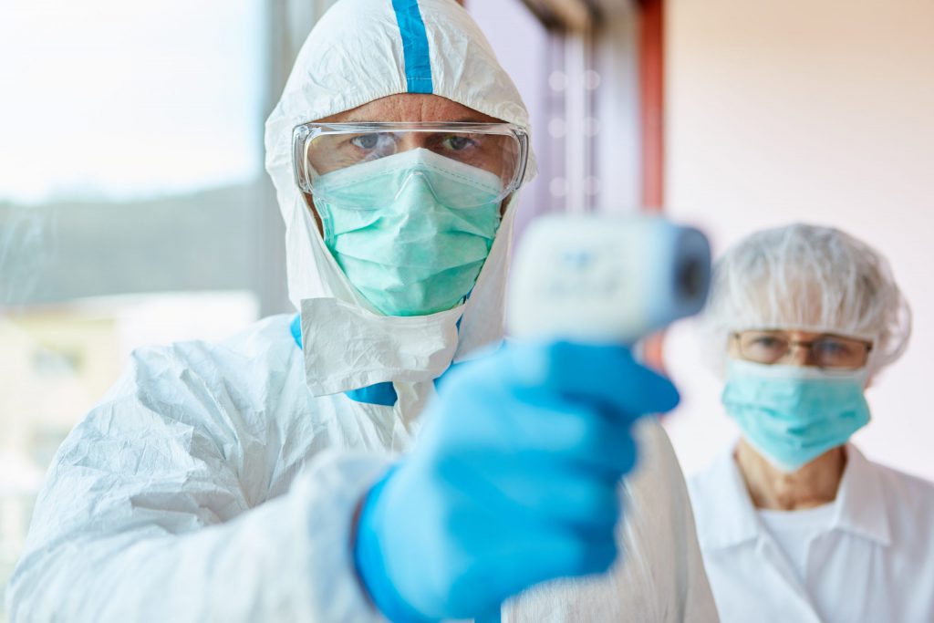 Doctor with PPE kit Checking Patient's Temperature