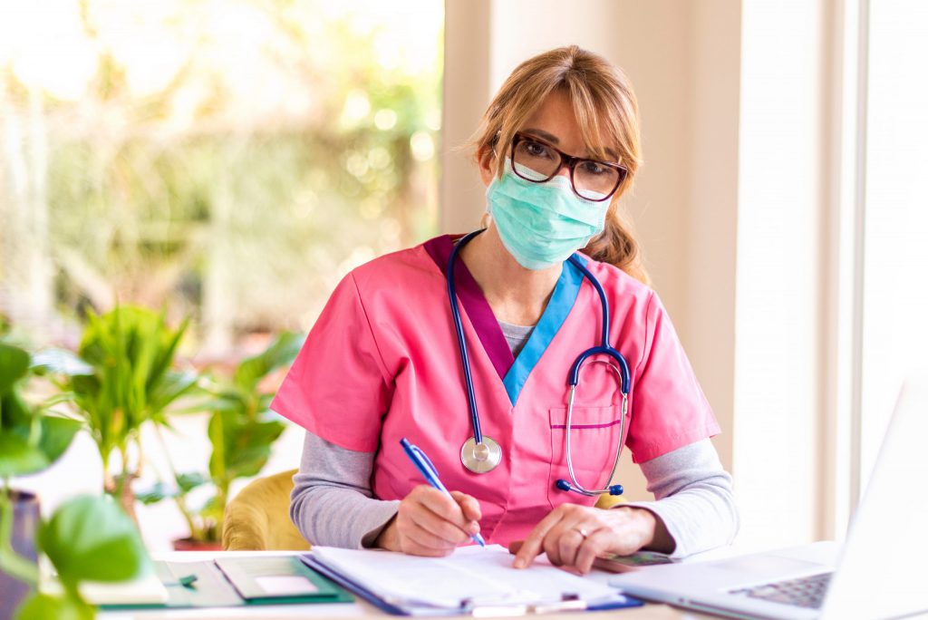 Nurse wearing mask and checking reports
