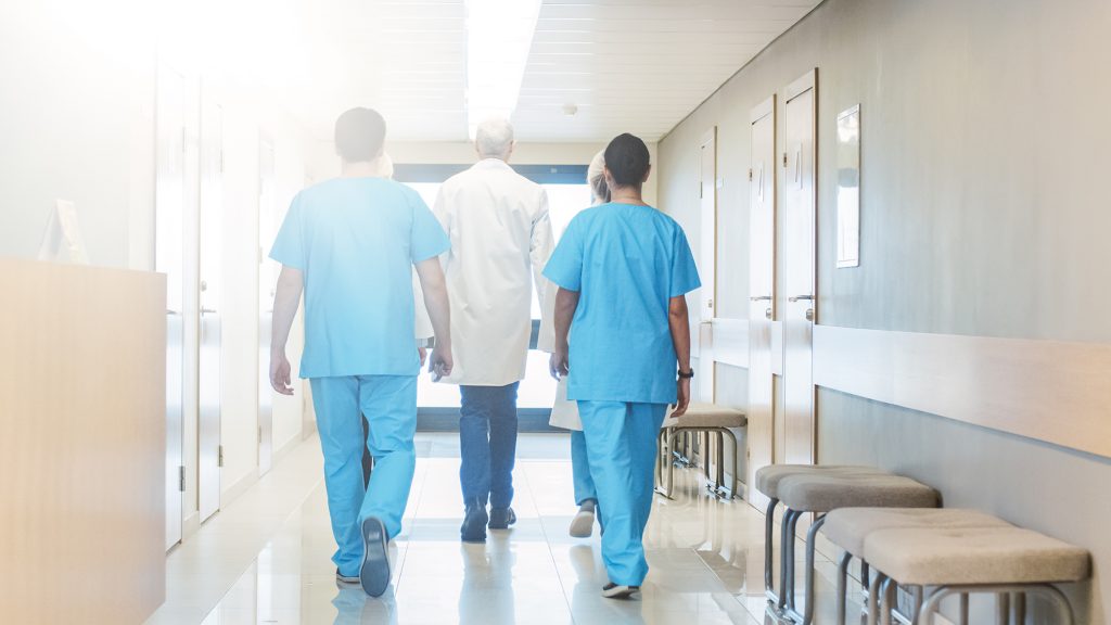 Group of Doctors Walking Through Hospital